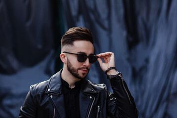 fashionable man adjusting his sunglasses