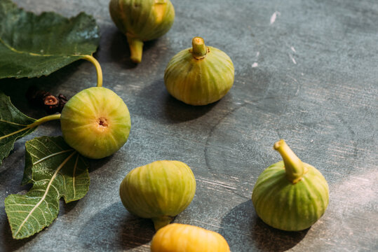 Ripe sweet green figs, freshly harvested from domestic tree, on table with grunge texture. Also known as ripe white figs 