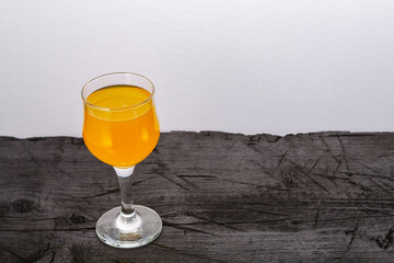 Orange juice in a glass on a black background.