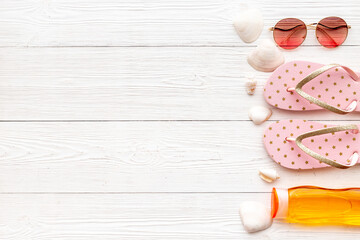 Top view of summer beach accessories with sunglasses and flip flops
