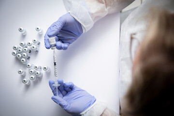 Anonymous female doctor with vaccine bottle and syringe