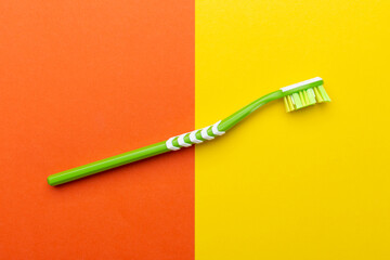 Toothbrush on a yellow-orange background. Hygiene of the oral cavity.