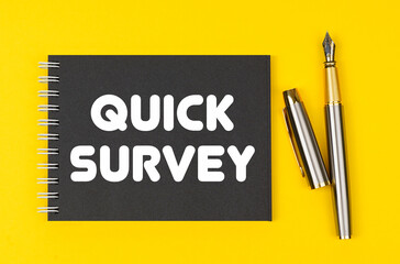 On a yellow background lies a pen and a black notebook with the inscription - Quick Survey