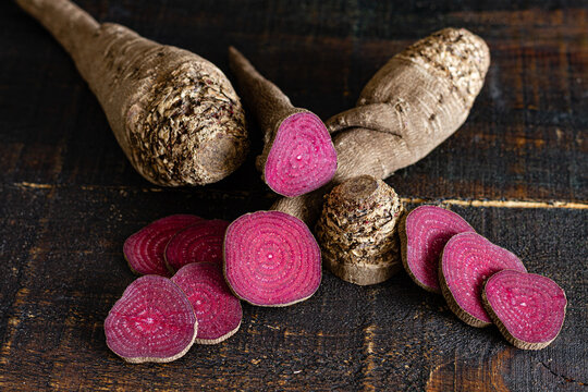 Overhead composition of organic natural beetroot cut into slices and arranged on shabby wooden surface