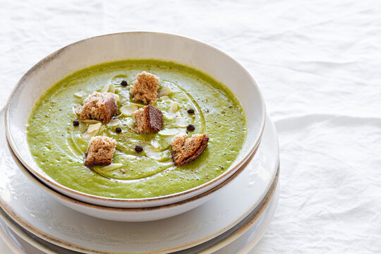 From above of yummy zucchini cream soup with croutons in bowl served on table at home