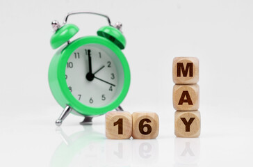 On a white background there is an alarm clock and a calendar with the inscription - MAY 16