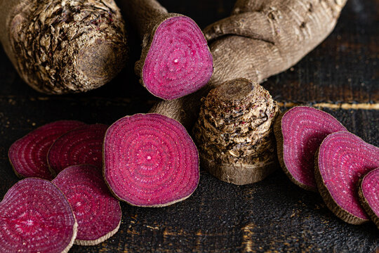 Overhead composition of organic natural beetroot cut into slices and arranged on shabby wooden surface