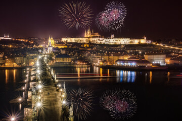 Amazing view of bright fireworks exploding in dark night sky over city with illuminated buildings