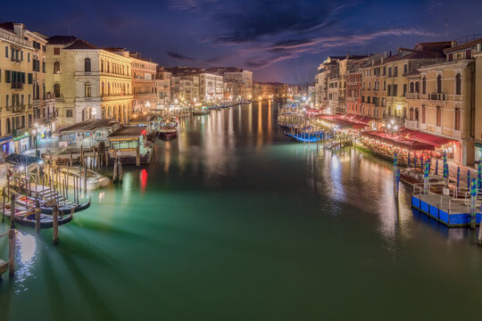 Scenic view of Grand Canal between old residential buildings under evening sky in Venice