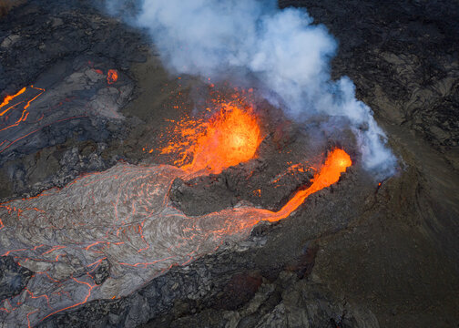 From above magma sparks out of the volcano hole and run like rivers of lava over the ground in Iceland