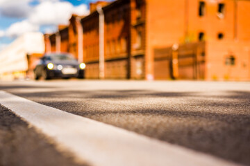 Summer in the city, the car driving on empty street. Close up view from the level of the dividing line