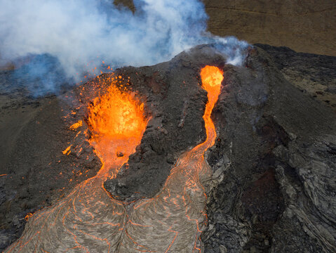 From above magma sparks out of the volcano hole and run like rivers of lava over the ground in Iceland