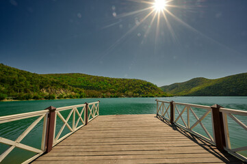 view of the green hills and lake from the pier