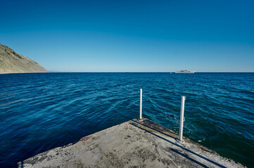 view of the yacht in the sea and the coast from the pier