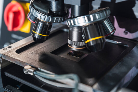 Contemporary professional microscope with powerful lenses placed on table in modern equipped lab