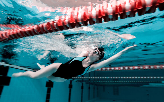 Woman crawling in a pool preparing for a competition