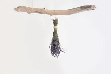 Foto op Plexiglas Dried bunch of lavender hanging upside down on a piece of old driftwood. © Sarah