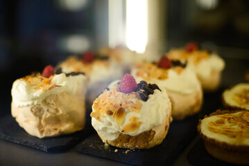 Delicious cream cake with raspberry, roasted almonds and chocolate on top.