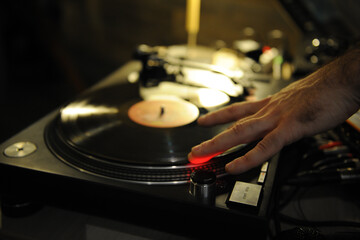 DJ plays live set and mixing music on turntable in the night club. station at club party. DJ mixer controller panel for playing music and partying.