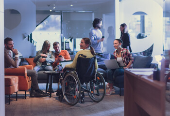 Obraz premium Handicapperd businesswoman in a wheelchair on meeting with her diverse business team brainstorming at office