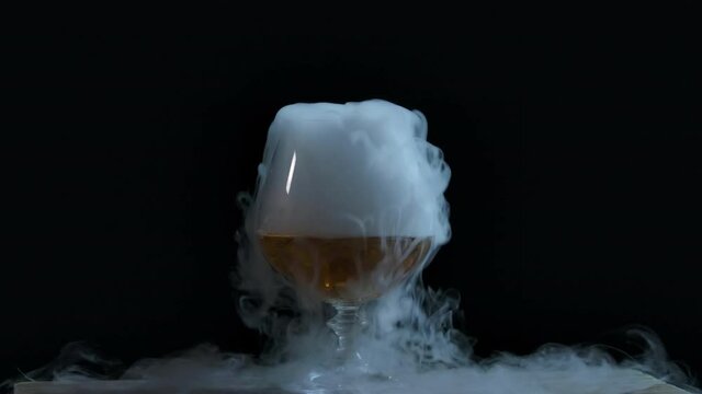 The abstract  smoke in the glass. White wine in glass with dry ice