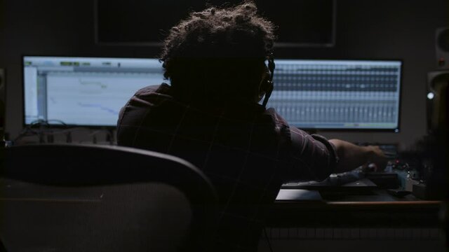 Music producer working on his latest track in his record studio. 