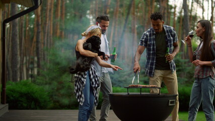 Cute woman holding dog on hands outside. Relaxed friends spending time in forest