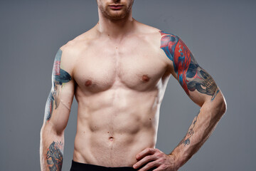 Naklejka premium sporty man with a pumped-up torso tattoo on his arms cropped view model