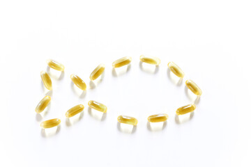 Wooden spoon of Omega-3 capsules on white background. Fish oil in pills. Health support and treatment. Biologically active additives. Copy space selective focus. 