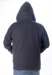 Fototapeta na wymiar person with black hooded jacket, standing with back turned, in front of white background. hoodie.