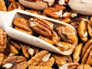 wooden scoop in pecan nuts close up