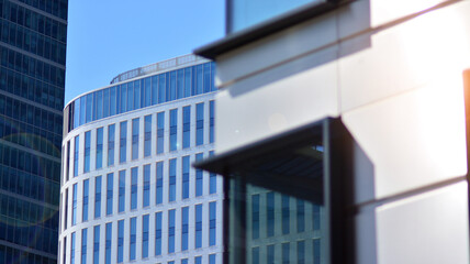Modern architecture with sun ray. Glass and steel facade on a bright sunny day with sunbeams on the blue sky. Economy, finances, business activity concept.