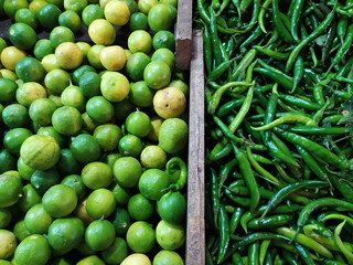 Two half of green chiles and lime in one frame separated from wood - Stock photo
