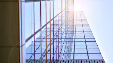 Fototapeta na wymiar Modern architecture with sun ray. Glass and steel facade on a bright sunny day with sunbeams on the blue sky. Economy, finances, business activity concept.