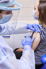 Fototapeta premium Close up of a Doctor making a vaccination in the shoulder of patient, Flu Vaccination Injection on Arm, coronavirus, covid-19 vaccine disease preparing for human clinical trials vaccination shot.