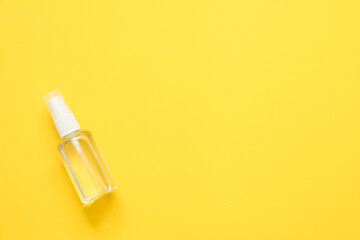 top view of alcohol spray in transparent plastic bottle on yellow background, Coronavirus protection equipment background concept.