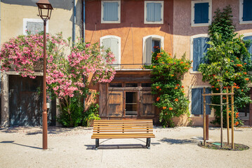 Traditional little provence french town houses entrance and facade surrounded by plant and flowers with outside bench