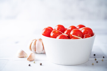 Pickled tomatoes in a bowl with garlic