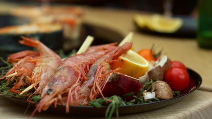 Prawns with vegetables served for bbq party. Closeup shrimp sticks on plate