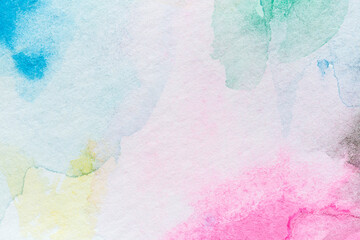 Macro close-up of an abstract colorful watercolor gradient fill background with watercolour stains. High resolution full frame textured white paper background.