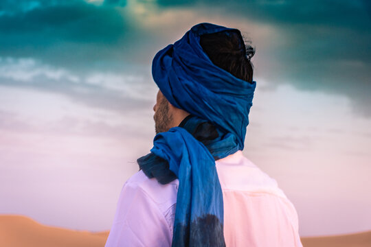 Berber man wearing traditional tuareg clothes in the Sahara Desert at dawn, Merzouga, Morocco