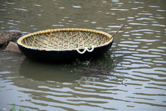 Newly built coracle decked with flowers with a row stick