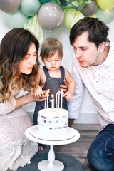Family celebrating birthday with a cake