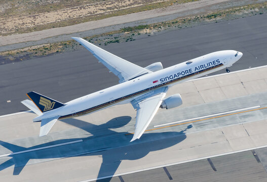 Singapore Airlines Boeing 777 departing LAX International Airport runway. Aerial view of B777 jet taking off. Aerial view.