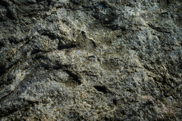 dark gray artistic background from the surface of the old mottled granite stone. moody image for design in grunge style