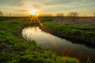 A curving river with a green shore and sunset, Stankow, Poland