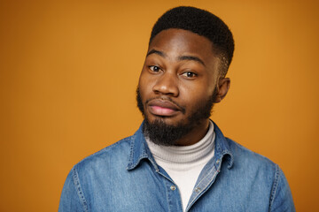 Fototapeta premium Portrait of young handsome african american guy against yellow background