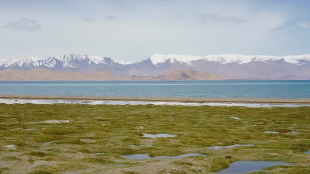 Snow mountains and blue Karakul lake along the Pamir Road in Tajikistan.