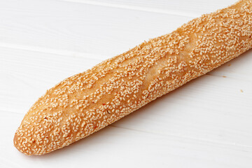 Fresh baguette bread on white wooden table