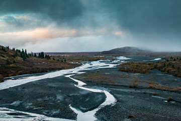 dramatic autumn landscape of snowcapped mountain ranges and peaks inside DEnali National park .